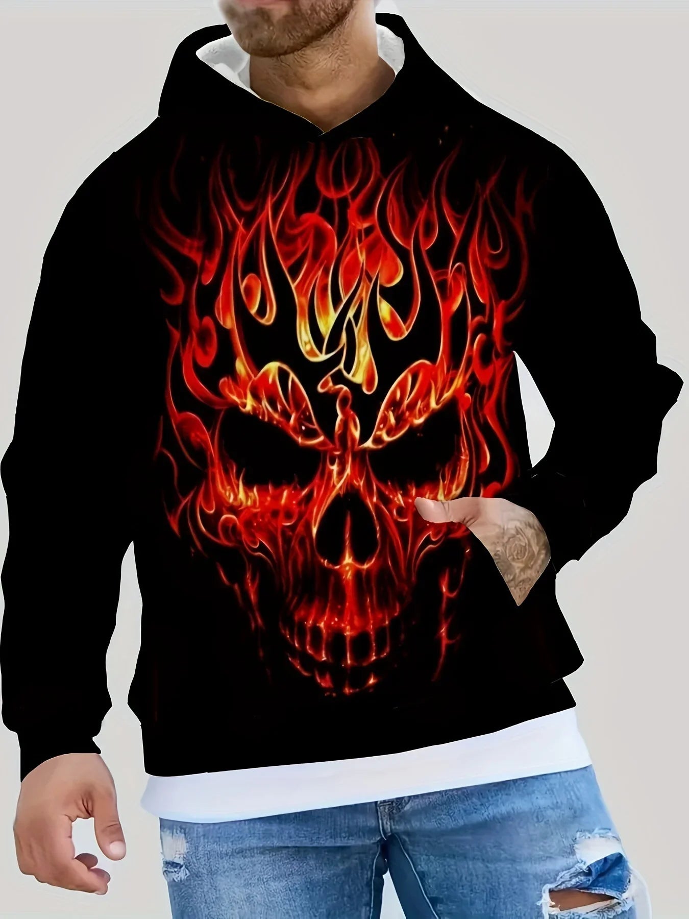 Black hoodie with bold flaming skull graphic, relaxed fit, worn with distressed jeans