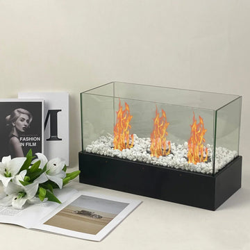 Rectangular glass tabletop fireplace with white stones and orange flames, modern minimalist decor