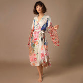 Woman wearing a floral kimono robe with colorful prints and loose, flowy fit