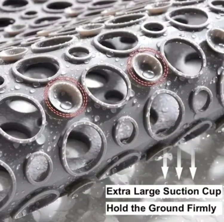 Close-up of gray rubber mat with large suction cups and water droplets, non-slip design