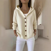 Cream knit button-up hoodie with relaxed fit, paired with white pants, casual style