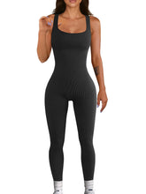Woman wearing a black ribbed sleeveless jumpsuit with a fitted, seamless design