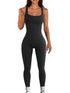 Woman wearing a black ribbed sleeveless jumpsuit with a fitted, seamless design