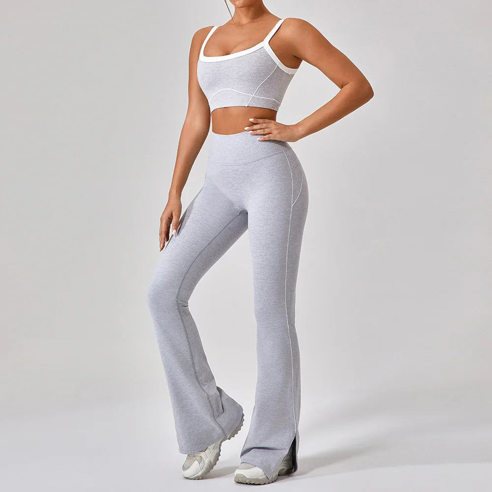 Woman wearing fitted light gray flared leggings and crop top set with white trim.