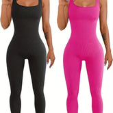 Two women wearing ribbed sleeveless jumpsuits, one in black and one in hot pink, slim fit.