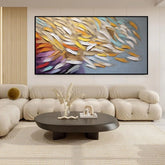 Modern living room with tufted beige sofa, cream fabric, and abstract colorful wall art