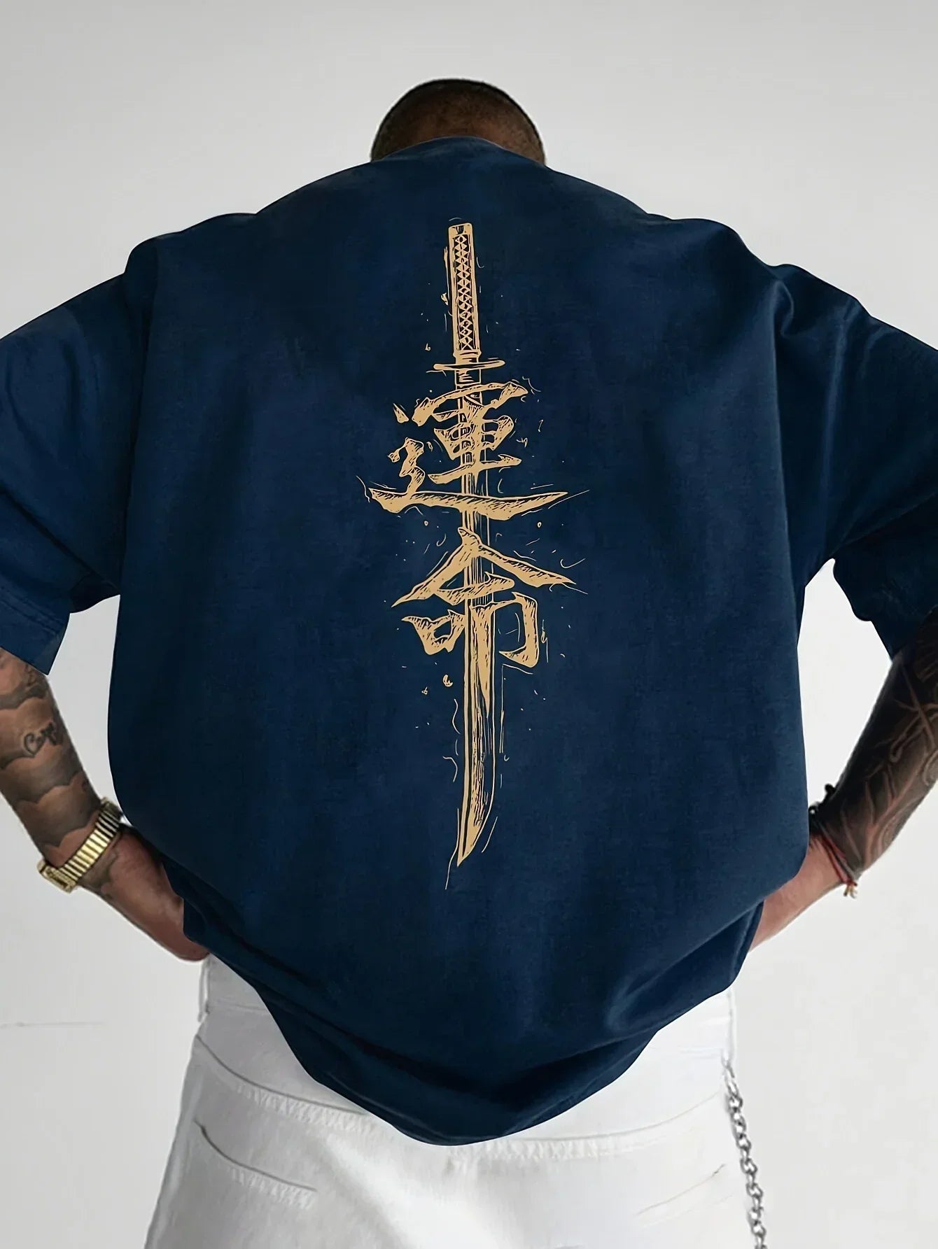 Oversized navy blue t-shirt with bold gold sword and kanji graphic on the back, streetwear style