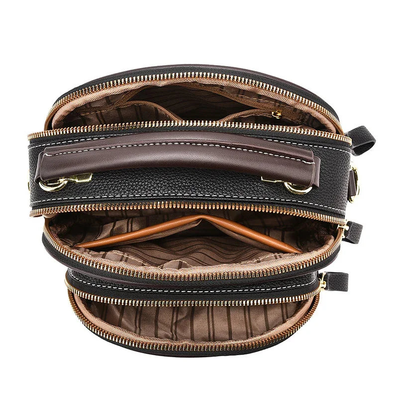 Black and brown leather crossbody bag with multiple zippered compartments and striped lining