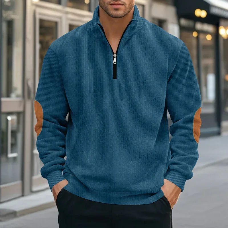 Men's blue ribbed quarter-zip pullover with tan suede elbow patches, relaxed fit