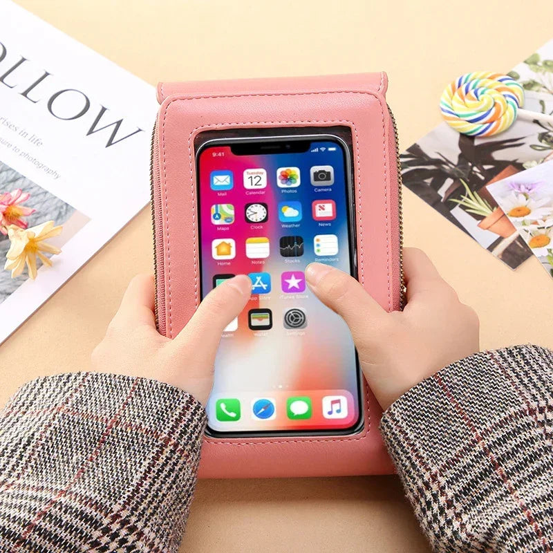 Plaid sleeve hands using smartphone through pink faux leather touch screen pouch