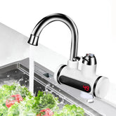 Modern stainless steel kitchen faucet with digital temperature display and running water over fresh vegetables in a sink