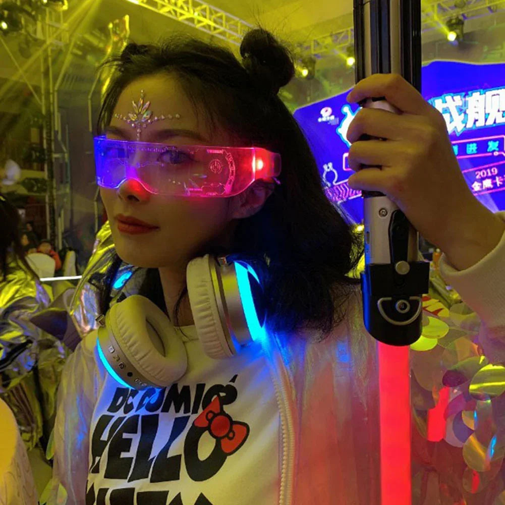Woman in neon light futuristic streetwear, transparent jacket, graphic tee, and LED visor