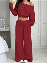 Woman wearing a red off-shoulder crop top and wide-leg lounge pants set, relaxed fit.