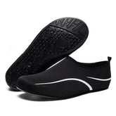 Black slip-on water shoes with white wave accents, mesh material, flexible rubber sole