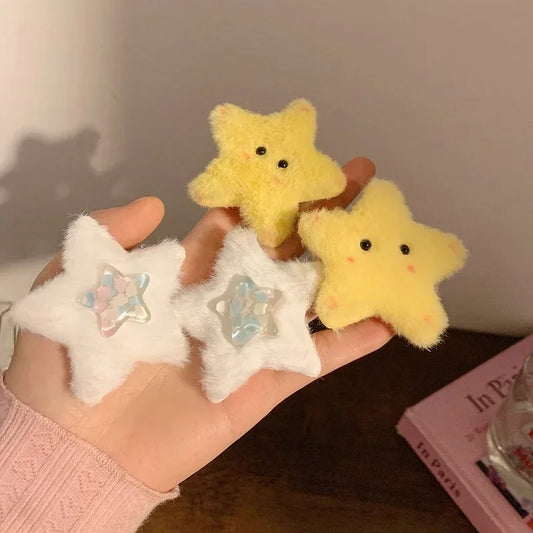 Hand holding soft plush star hair clips in yellow and white, fluffy texture, cute accessory.