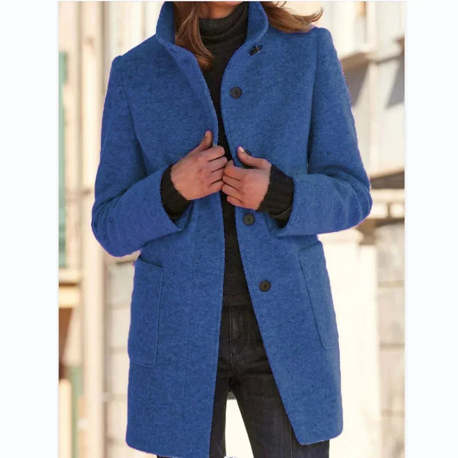 Woman wearing a blue wool coat, tailored fit, with large buttons and front pockets