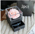Gift box with a pink artificial rose and black drawer displaying blue beaded bracelets