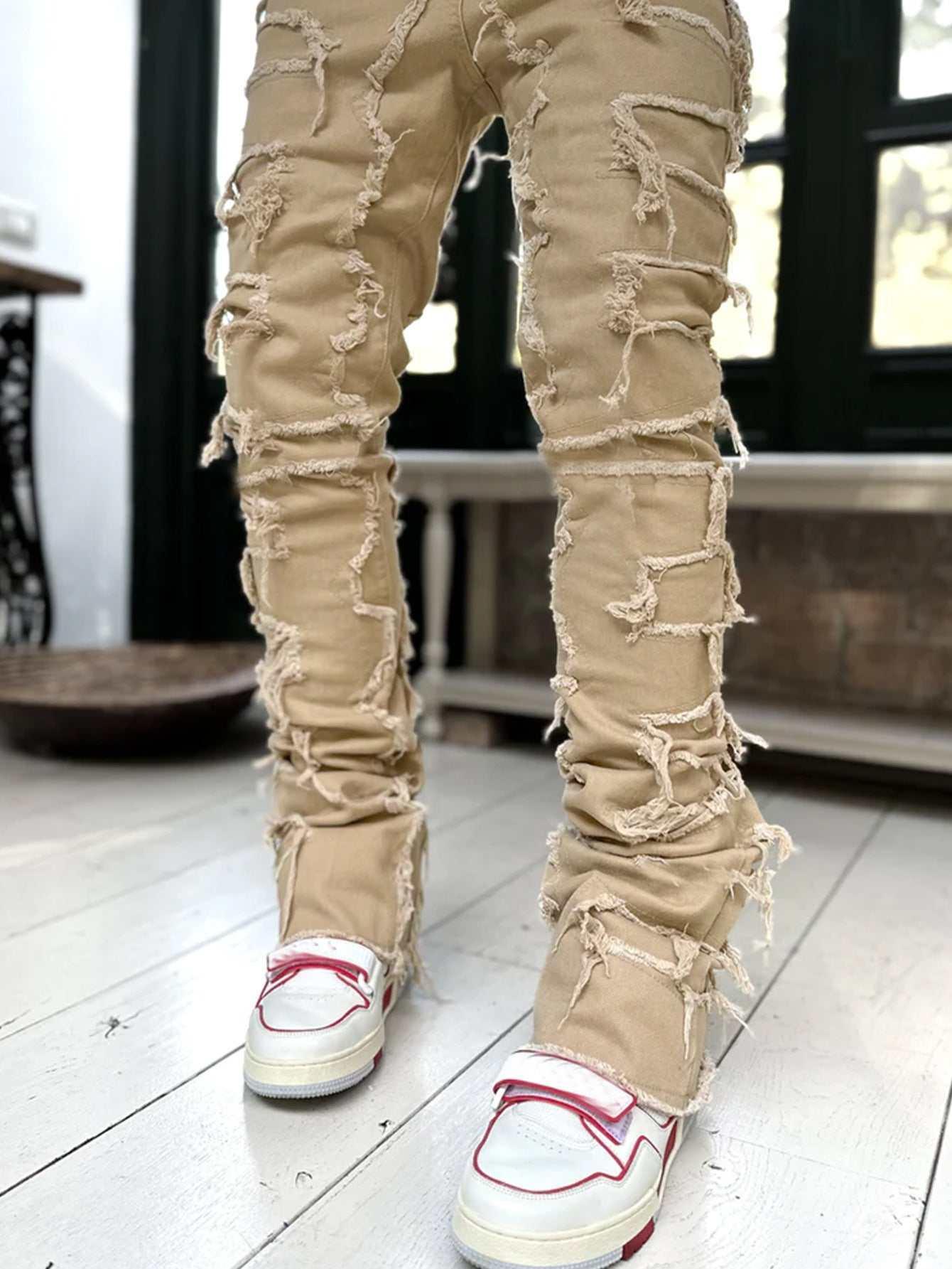 Beige distressed skinny jeans with heavy frayed detailing, paired with white sneakers