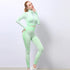 Woman in mint green seamless textured athletic set, zip-up crop top and high-waisted leggings