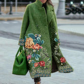 Woman wearing a long green wool coat with floral embroidery, relaxed fit, artistic street style.