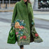 Woman wearing a long green wool coat with floral embroidery, relaxed fit, artistic street style.