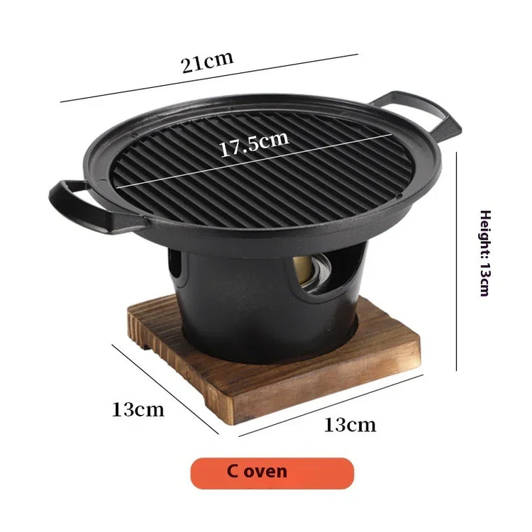 Compact black cast iron tabletop grill with ribbed round grill top, wooden base, and size dimensions labeled.