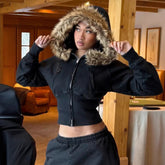 Woman wearing black cropped zip-up hoodie with faux fur hood and relaxed fit joggers indoors