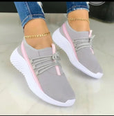 Lightweight grey mesh sneakers with pink accents, white soles, and slim fit design