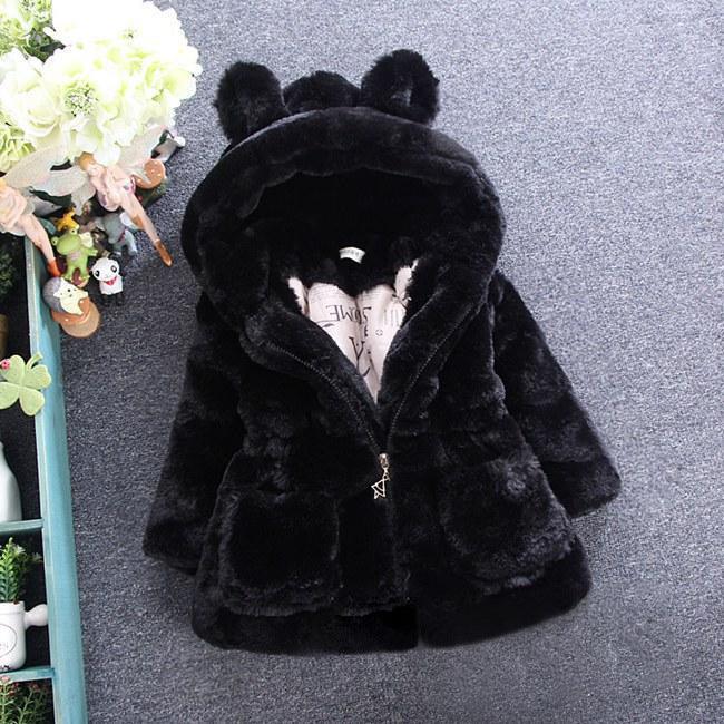 Black faux fur hooded jacket with bear ears, plush material, relaxed fit, laid flat on floor