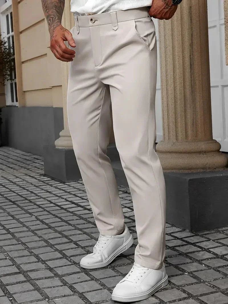 Man wearing slim fit beige dress pants with front pockets and white sneakers