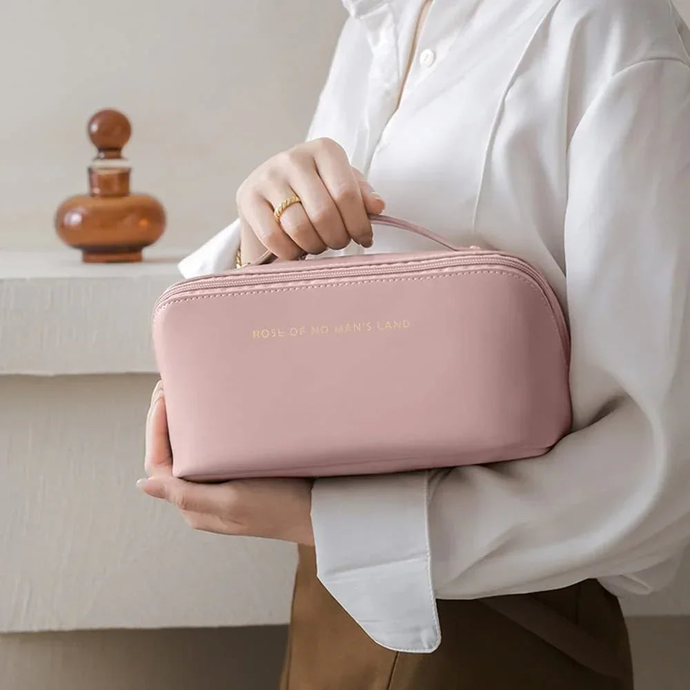 Woman in a white blouse holding a soft pink zippered pouch with structured fit