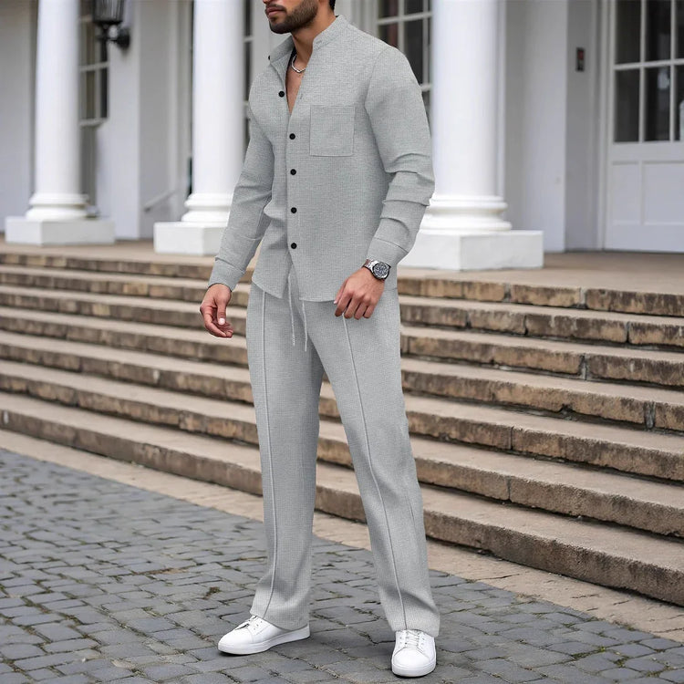 Man wearing light grey textured lounge set with button-up shirt and drawstring pants, relaxed fit