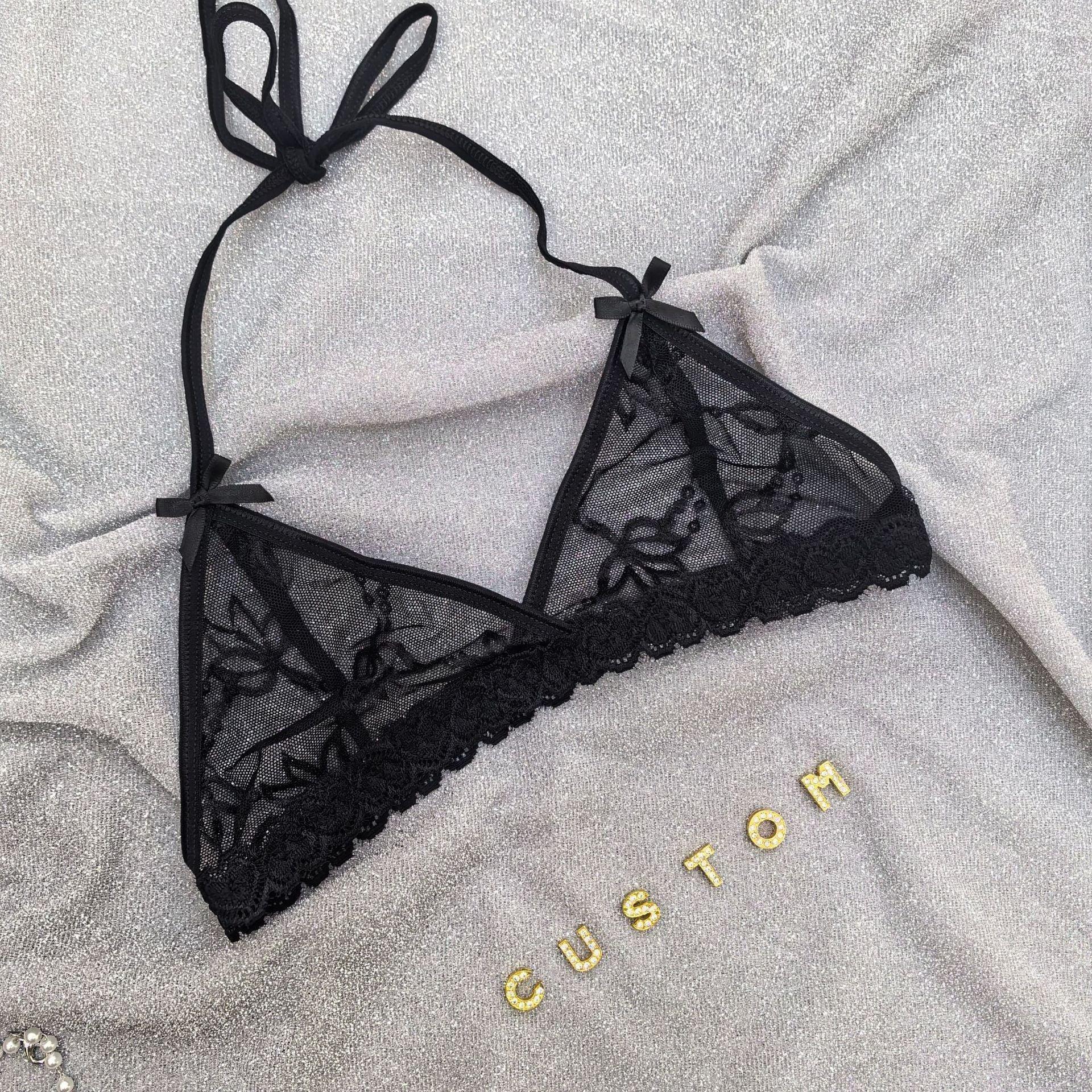 Sheer black lace bralette with floral embroidery, halter tie, and scalloped trim on silver fabric