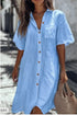 Woman wearing loose fit light blue button-up linen shirt dress with short sleeves