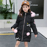 Girl in a long black puffer coat with pink faux fur trim and pom poms, casual street style