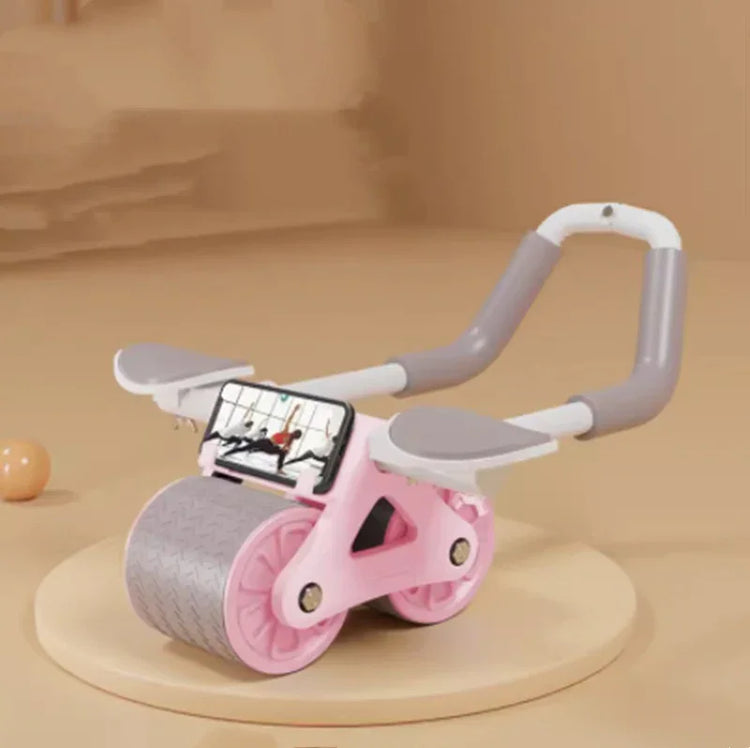 Pink and gray ab roller with phone holder, ergonomic handles, and rubber wheels on beige background
