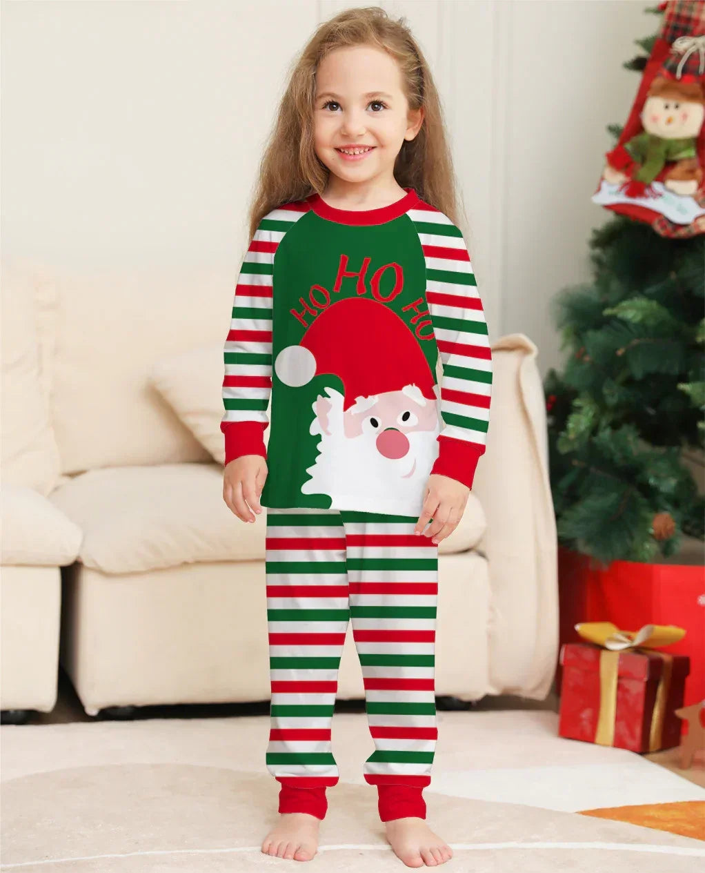 Child in festive striped Christmas pajamas with Santa graphic, long sleeves, relaxed fit