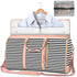 Black and white striped weekender bag with light pink accents, holding a light blue collared shirt, and a clear zippered pouch.