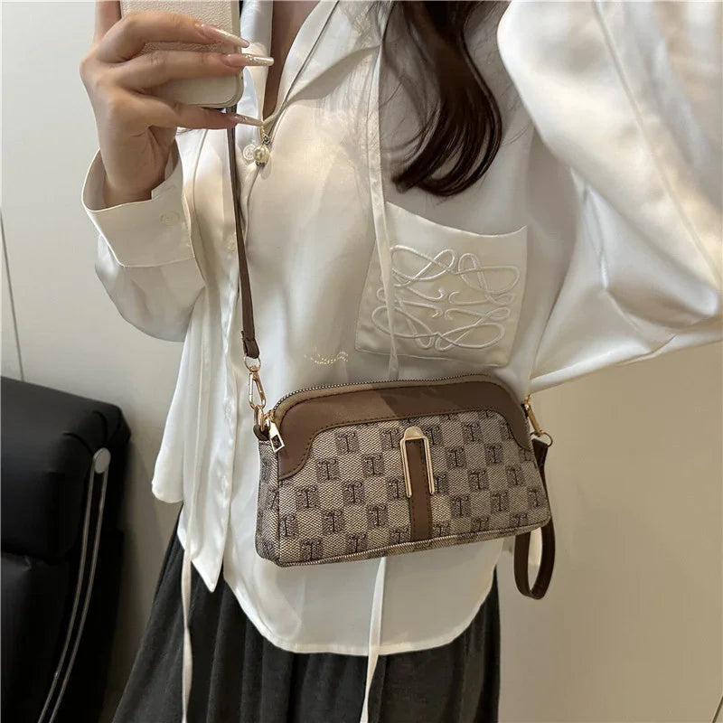 Woman in loose white satin blouse with embroidery, wearing brown checkered crossbody bag