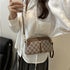 Woman in loose white satin blouse with embroidery, wearing brown checkered crossbody bag