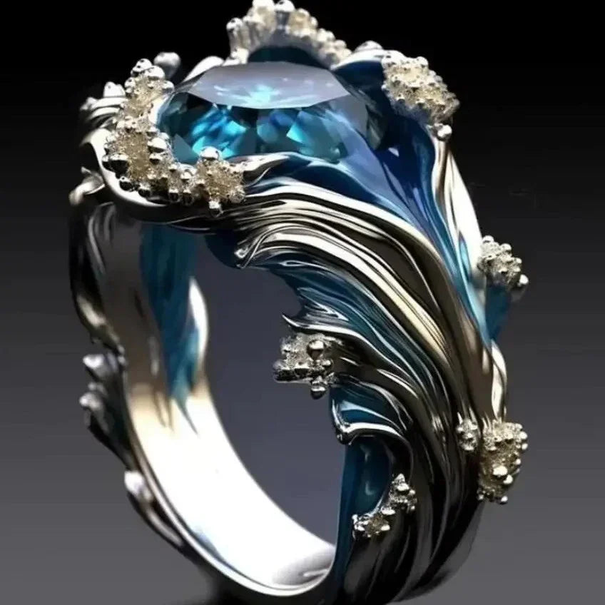 Silver and blue gemstone ring with wave-like design and crystal accents