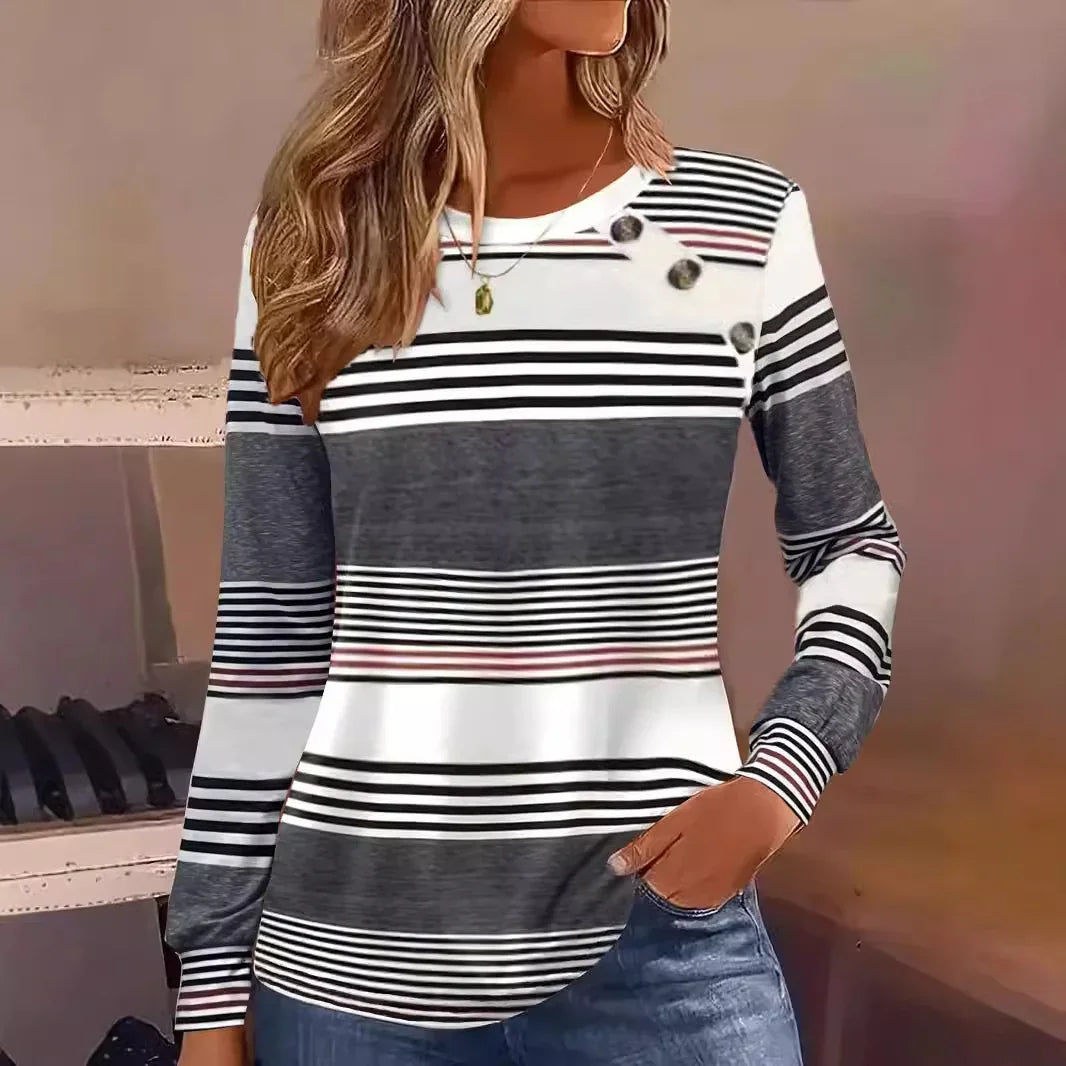Woman wearing a long sleeve striped knit top in black, white, and gray with button details.