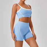 Woman wearing light blue athletic crop top and matching high-waisted shorts with white trim
