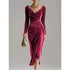 Woman wearing a deep pink velvet midi dress with long sleeves and draped cowl neckline