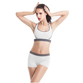 Woman wearing white athletic sports bra and shorts with gray trim, fitted and seamless style