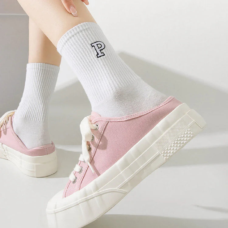 Pink canvas sneakers with thick white soles and white ribbed crew socks with a P logo