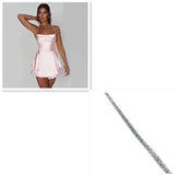 Woman in light pink satin mini dress with spaghetti straps and a silver tennis bracelet