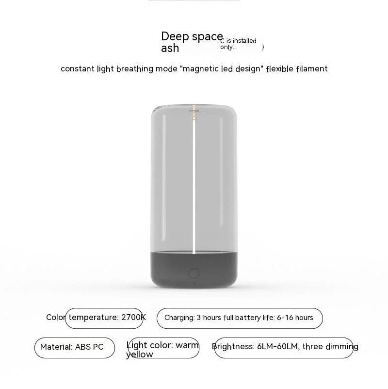 Modern grey portable LED lamp with transparent cylindrical body, warm yellow light, ABS PC material.