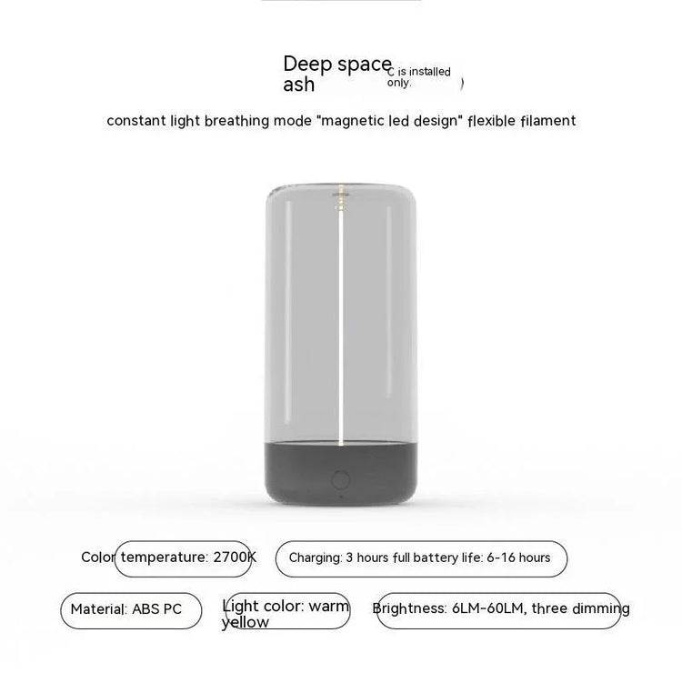 Modern grey portable LED lamp with transparent cylindrical body, warm yellow light, ABS PC material.