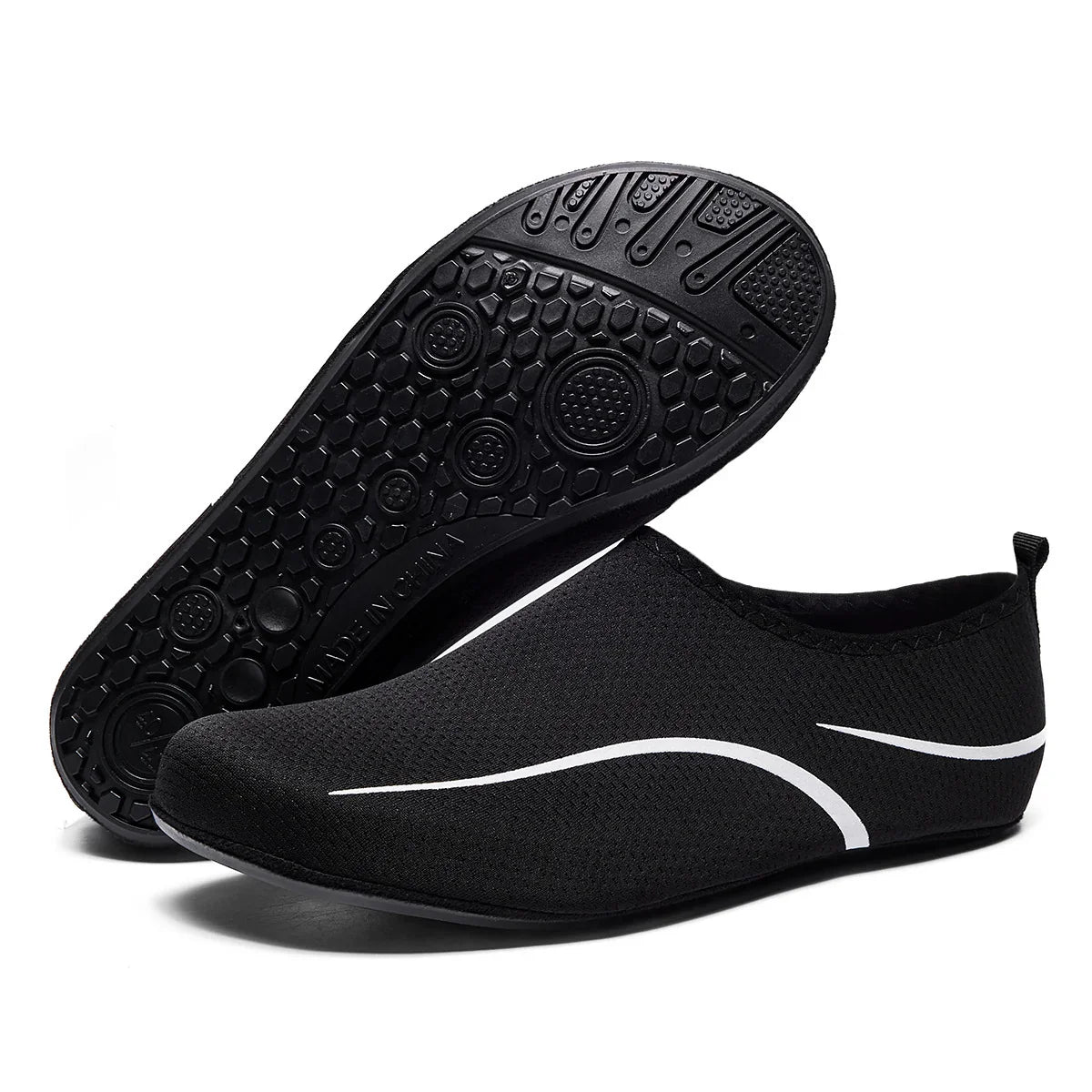 Black mesh slip-on sneakers with white accents and flexible rubber sole, minimalist design.